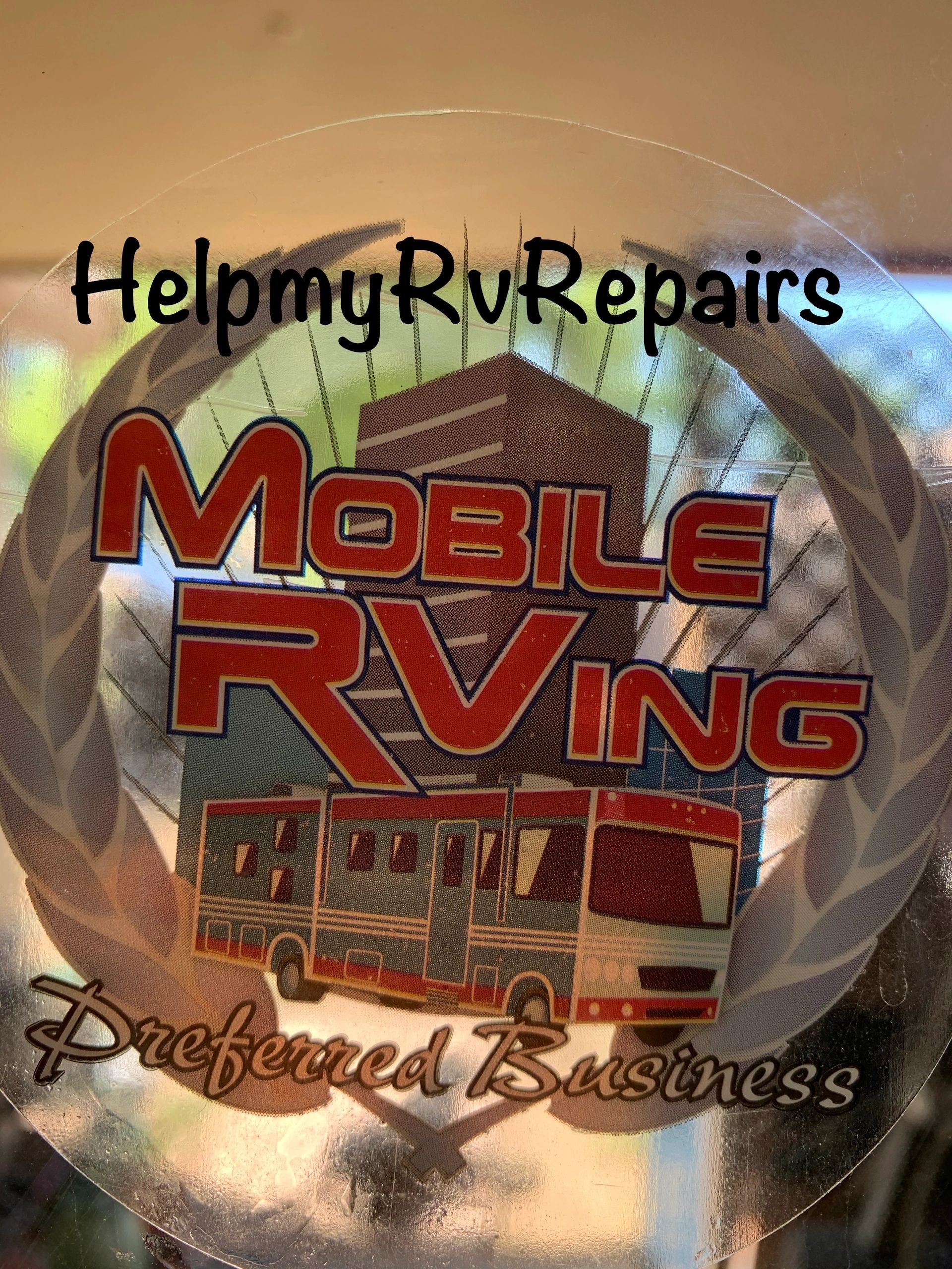 A clear window decal reading HelpmyRvRepairs applied to RV glass.
