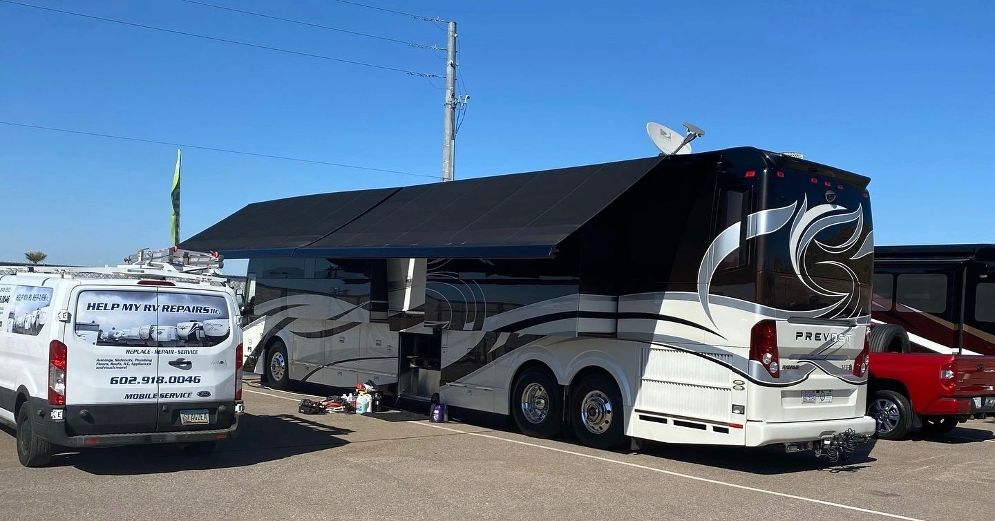 A Help My RV Repairs service van parked beside a Prevost coach with its patio awning extended on an Arizona lot.